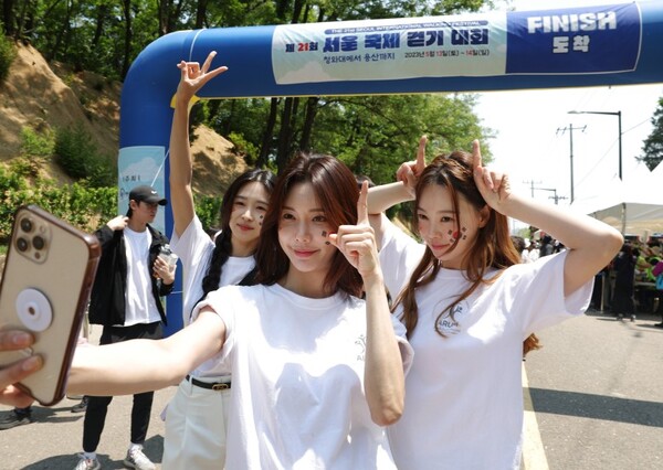 서울국제걷기대회 참가자들이 13일 오전 서울 용산어린이정원에 도착해 완보증을 받은 뒤 기념 사진을 찍고 있다. 